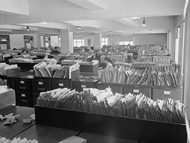Wartime found Government employees working in poorly-lit, crowded offices such as the Records and Files Department of the Experimental Farm.  Courtesy of Library and Archives Canada. MIKAN no. 3202901.